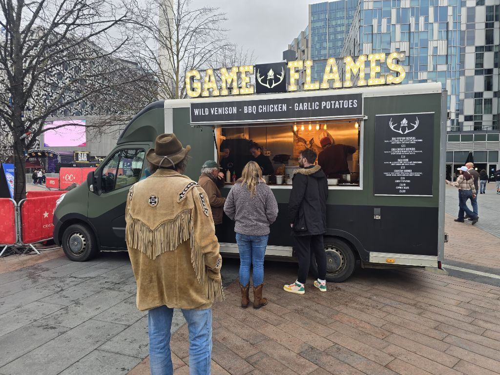Game and Flames food truck in a city centre with lit-up sign
