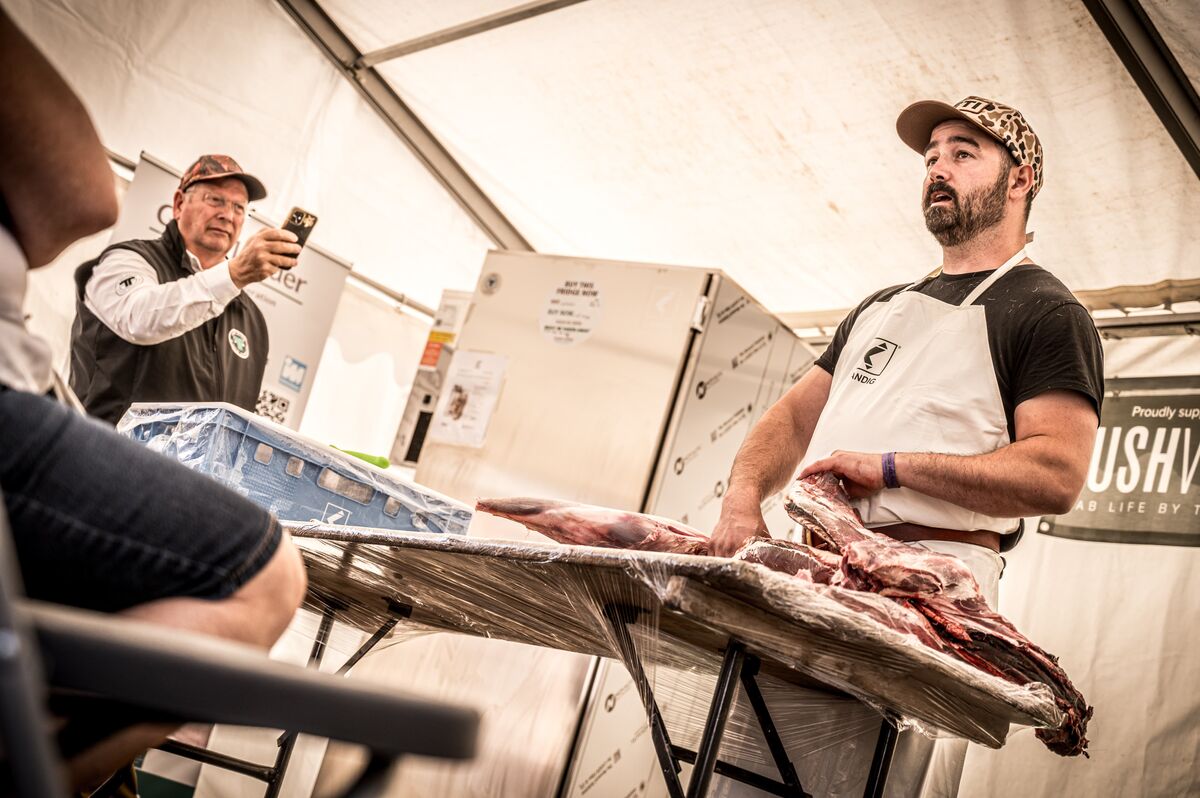 Cai Ap Bryn presenting a butchered deer carcass during a workshop demonstration